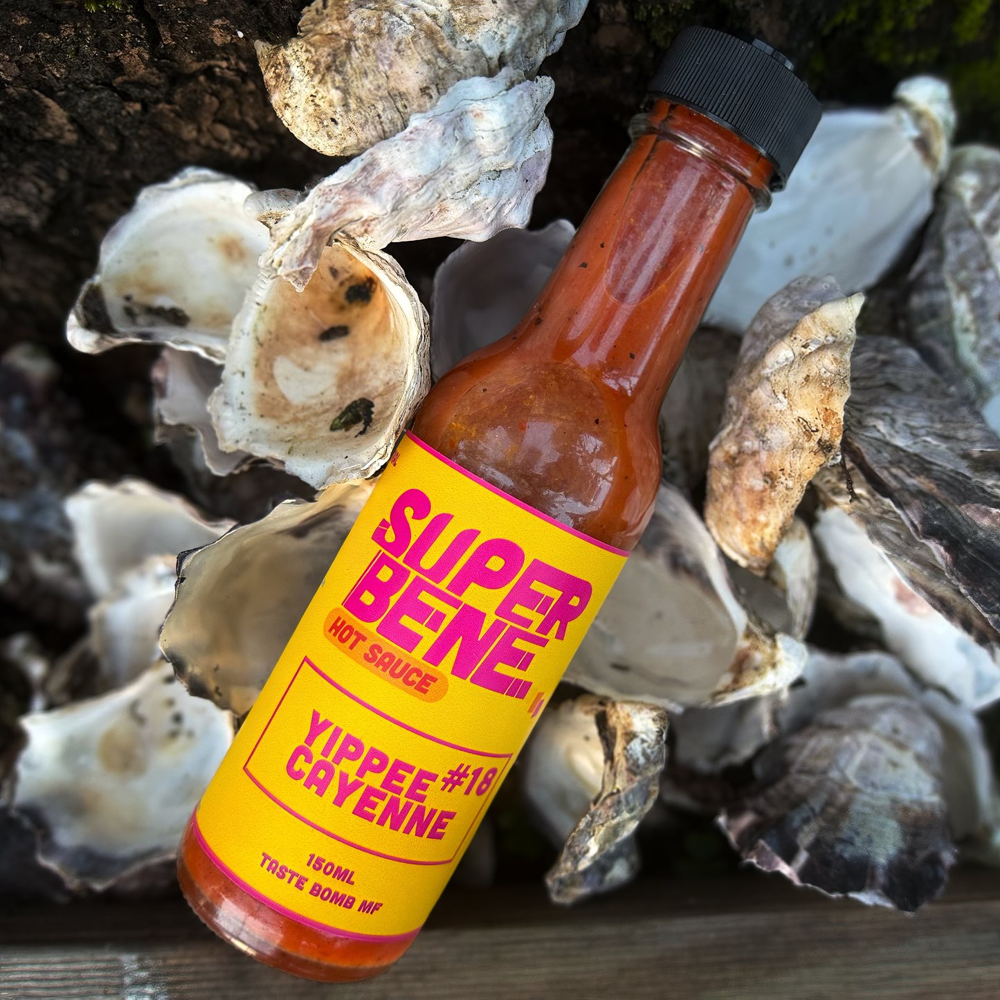 Super Bene hot sauce bottle with a yellow label on oyster shells