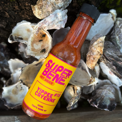 Super Bene hot sauce bottle with a yellow label on oyster shells